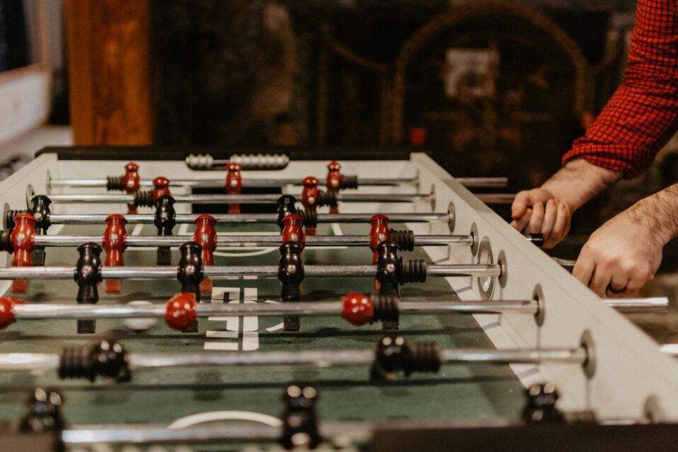 person playing foosball table